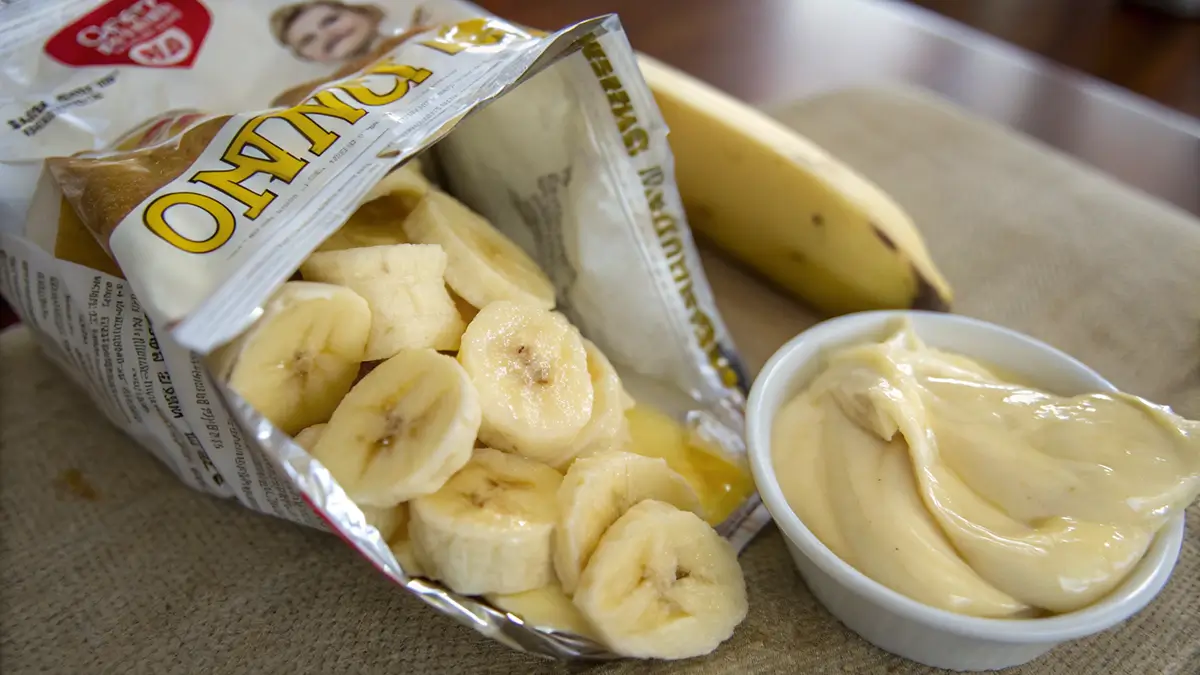 Open chips bag filled with Walking Banana Pudding and banana pudding next to a fresh banana.
