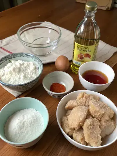 Ingredients for tempura chicken nuggets displayed on a kitchen table.